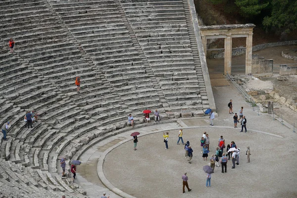 Los turistas visitan el Teatro Epidaurus (Peloponeso, Grecia), que es uno de los mayores ejemplos de la arquitectura griega — Foto de Stock