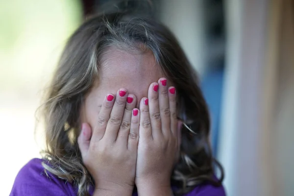 एक 4 साल की लड़की अपने चेहरे को छुपाती है — स्टॉक फ़ोटो, इमेज