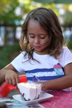 Dondurma yiyen 4 yaşındaki bir kızın portresi.
