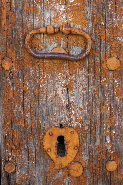 An old metal handle on a wooden door — Stock Photo, Image