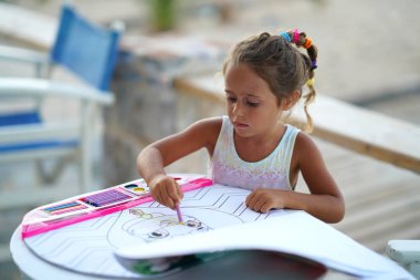 4-year-old girl colors with interest