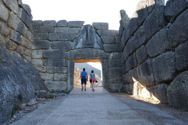 Los turistas visitan el sitio arqueológico al entrar en la puerta de los Leones. — Foto de Stock