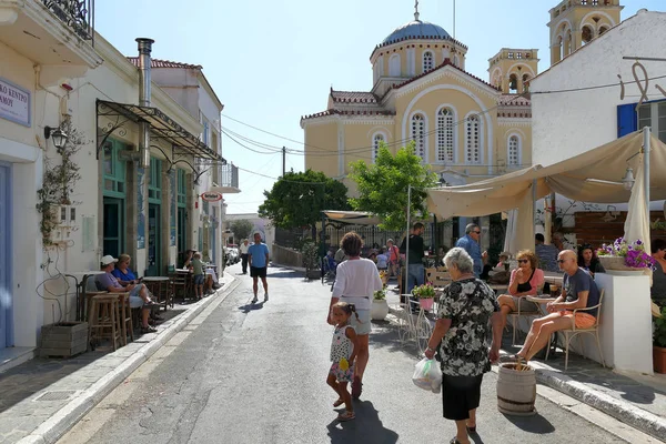 Tourists of various nationalities relax by strolling through the center in Potamos, Greece — Stock Photo, Image