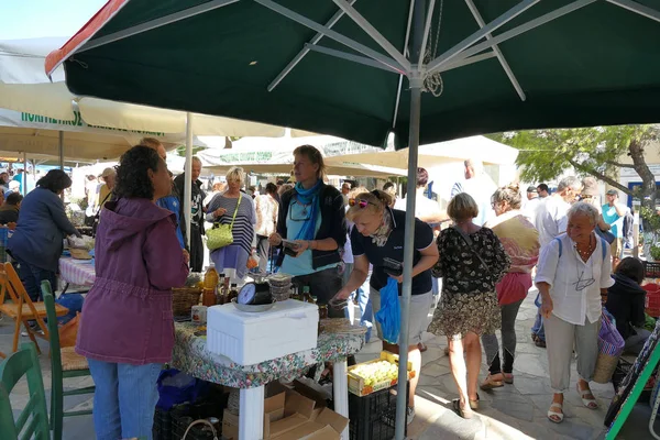 Touristen verschiedener Nationalitäten kaufen auf dem charakteristischen Markt für typische Produkte in Potamos, Griechenland — Stockfoto