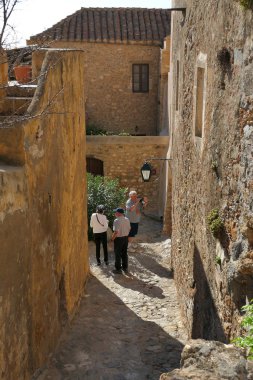 Turistler, Monemvasia 'nın efsanevi şatosunun içindeki kenti ziyaret ediyorlar.