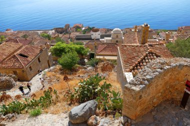 Turistler, Monemvasia 'nın efsanevi şatosunun içindeki kenti ziyaret ediyorlar.