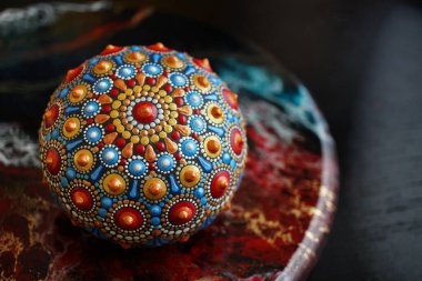 Siyah arka planda güzel bir el boyaması mandala taşı.