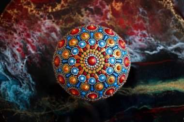 Siyah arka planda güzel bir el boyaması mandala taşı.