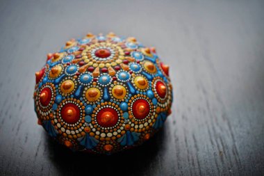 Siyah arka planda güzel bir el boyaması mandala taşı.