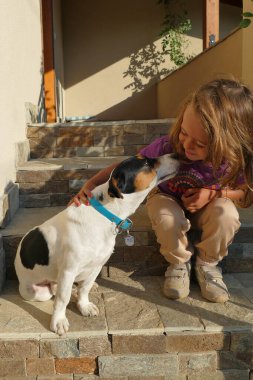 4 yaşındaki kız evde küçük köpeğiyle oynuyor.