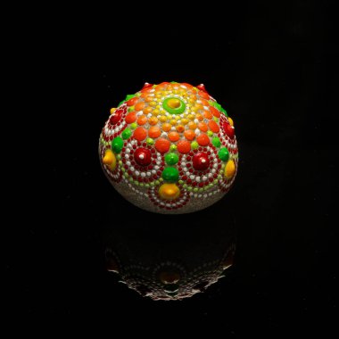 Siyah arka planda güzel bir el boyaması mandala taşı.