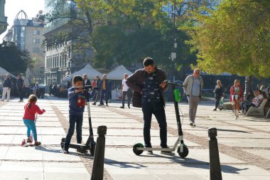 Sofya, 27 Ekim 2019, baba ve oğul Sofya 'da bir parkta elektrikli scooterlara bindiler.