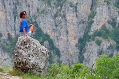 Bir turist, Yunanistan 'daki Vikos-Aoos parkındaki Oxya Bakış Amaçlı Vikos Boğazı' nın güzel manzarasına hayran.