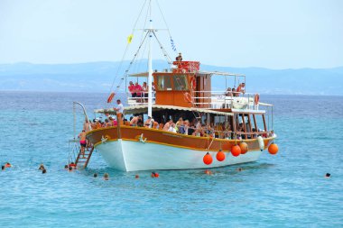 Karidi, Yunanistan, 19 Haziran 2019. Yunanistan 'da, Karidi' nin kaya oluşumlu plajlarından birinde turistlerle dolu bir tekne.