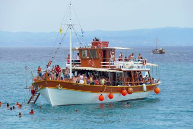 Karidi, Yunanistan, 19 Haziran 2019. Yunanistan 'da, Karidi' nin kaya oluşumlu plajlarından birinde turistlerle dolu bir tekne.