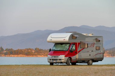 Trani Ammouda, Yunanistan, 20 Haziran 2019 Kamp aracı gün batımında deniz kenarında park etmiş.