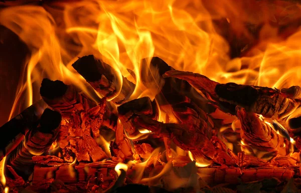Fire lit in the fireplace of a campsite with a beautiful bright red color, detail