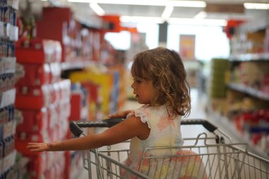 Yunanistan 'da süpermarkette 4 yaşındaki bir kız annesine bir şey gösteriyor.