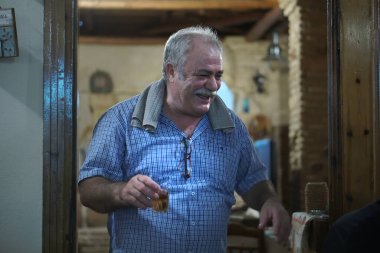 Kalamata, Yunanistan, 23 Temmuz 2018 Kalamata 'da bir meyhanenin sahibi müşterilerinin sağlığına kadeh kaldırıyor