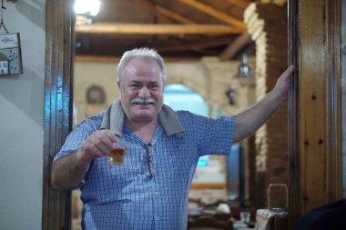 Kalamata, Yunanistan, 23 Temmuz 2018 Kalamata 'da bir meyhanenin sahibi müşterilerinin sağlığına kadeh kaldırıyor