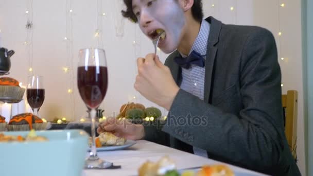 ハロウィン ディナー パーティー若いハンサムな男彼の食を楽しむ — ストック動画