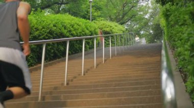 Genç Japon adam merdivenlerden yukarı yavaş çalışır