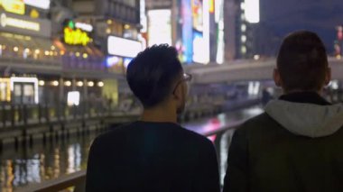 Uluslararası arkadaşlar yürürken bir kanal şehir Osaka, Japonya.