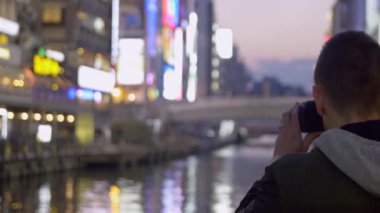 Neon ışıkları Japonya'nın Osaka fotoğrafını çekmek turist.