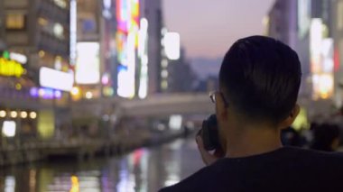 Neon ışıkları Japonya'nın Osaka fotoğrafını çekmek turist.