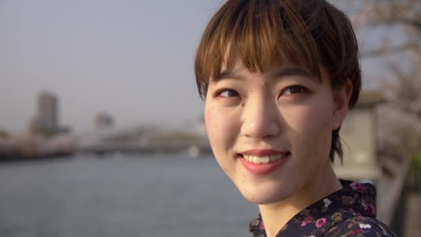 美丽的日本女人看着一条大河的樱花树 — 图库视频影像