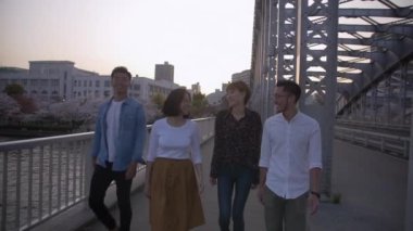 .Köprü, nehrin yanında güzel sakura boyunca yürüyüş uluslararası arkadaşlar