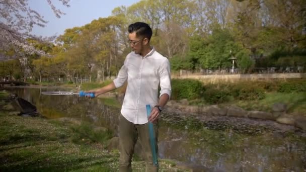 帅亚洲人在日本一个美丽的池塘制造泡沫 — 图库视频影像