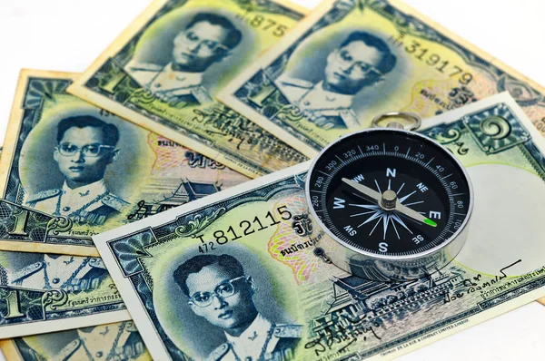 Tay kağıt para yığını üzerinde döşeme pusula