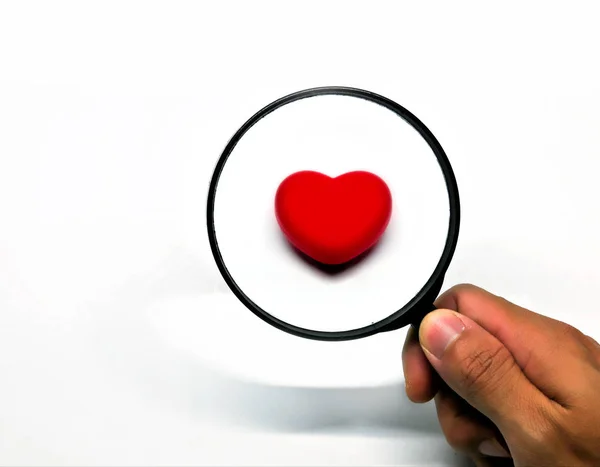 Büyüteç, isoleted beyaz backgrou üzerinde aracılığıyla kırmızı kalp