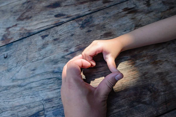 Babaların ve çocukların elleri birlikte birbirlerine olan sevgilerini göstermek için bir kalp sembolü haline gelirler..