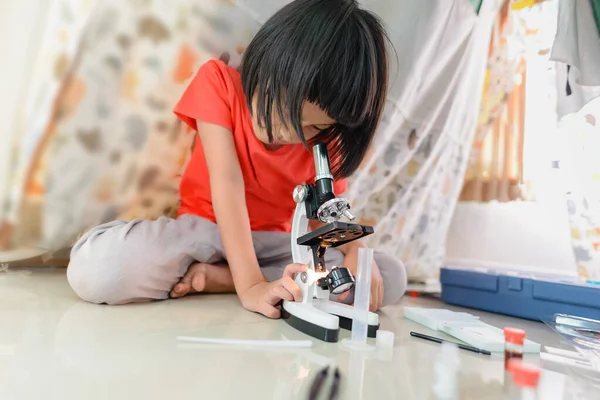 Kız bir şeye mikroskopla bir çocuk için bakıyor. Çadırını laboratuvar gibi kullanıyor. Muhtemelen bilim adamı olmak istiyordur..