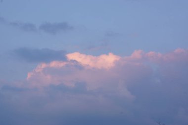 Akşam gökyüzünde muhteşem renkli bulutlar. Gün batımında gökyüzünde parlak, pembe bulutlar. Güzel bir akşam manzarası. Soyut, mor pembe arka plan. Canlı renkli fotoğraf..