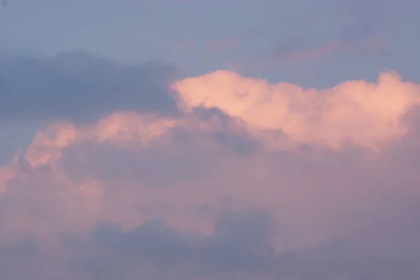 Magnificent colorful clouds in the evening sky. Bright, pink clouds in the sky at sunset. Beautiful evening skyscape. Abstract, purple pink background. Vibrant color photograph.