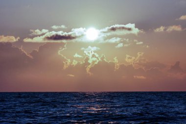 Bulutların arasından güneş ufukta oturur