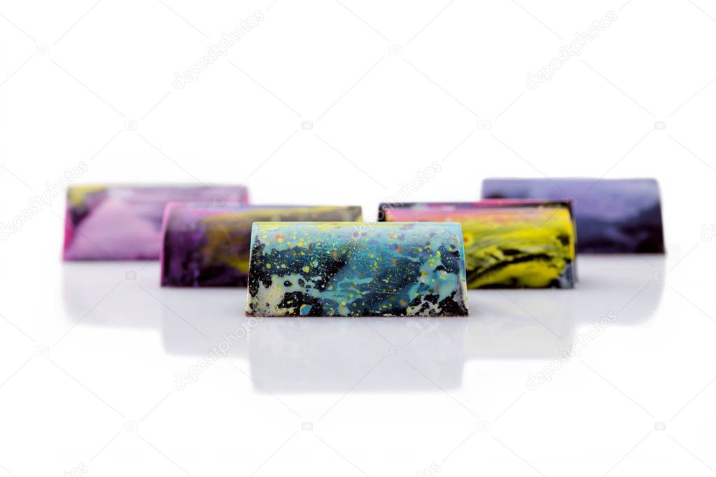 Colorful cakes with marble glaze on white background