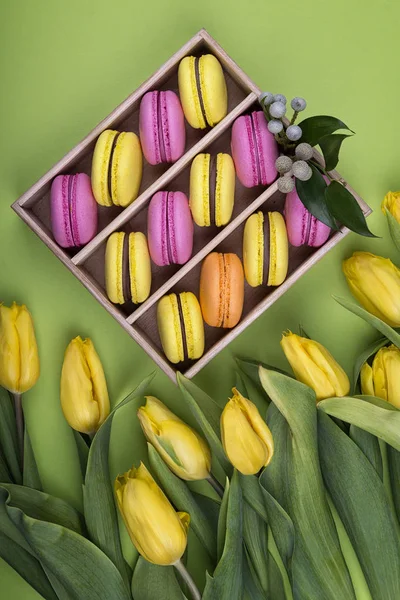 Pembe ve sarı macarons kutusunda taze Lale ile