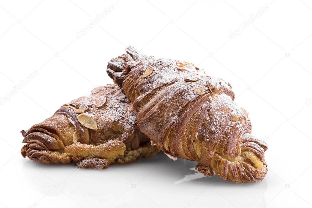 Fresh croissants with almond flakes and powdered sugar