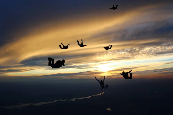 Gün batımı paraşütle atlama. Şaşırtıcı gökyüzü ve skydivers.