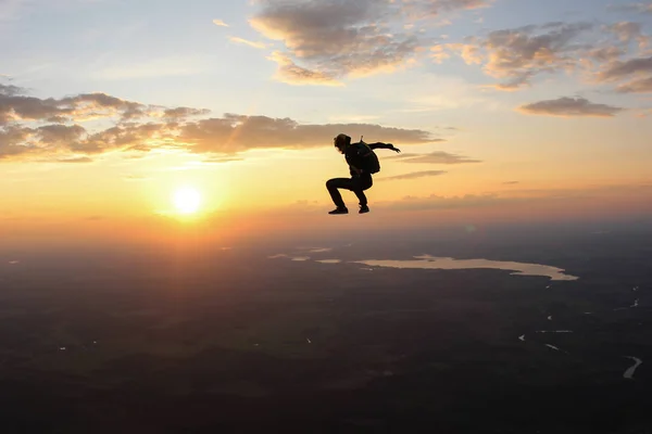 Gün batımı paraşütle atlama. Şaşırtıcı gökyüzü ve skydivers.
