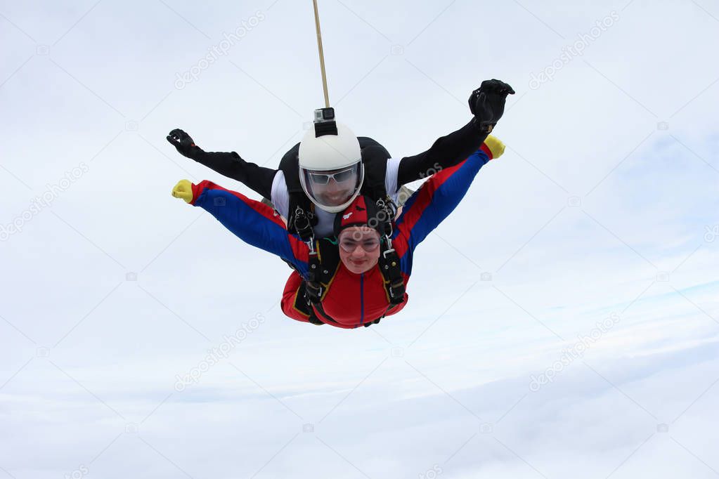 Skydiving. Girl-passenger and instructor are flying in the sky.