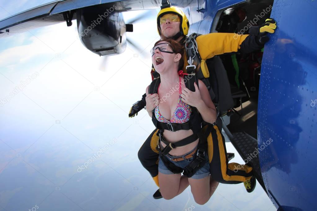 Skydiving. Tandem is jumping out of an airplane.