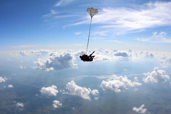 Skydiving. Tandem jump is in the blue sky.