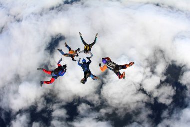 Beyaz bulutların üzerinde gökyüzünde eğitim skydivers vardır.