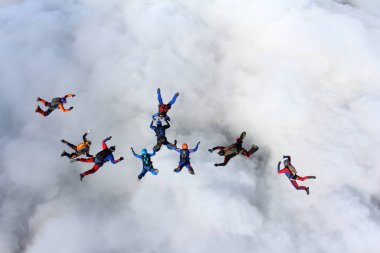 Beyaz bulutların üzerinde gökyüzünde eğitim skydivers vardır.