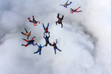 Beyaz bulutların üzerinde gökyüzünde eğitim skydivers vardır.